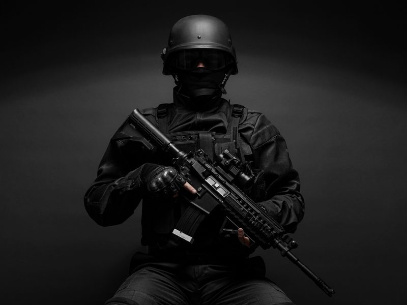 Law enforcement instructor in full tactical gear holding a rifle